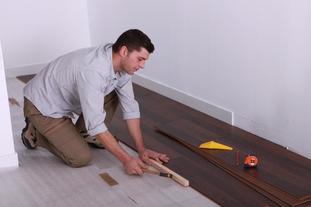 A man installing wood floors in a home.