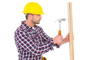 This is a picture of a handyman hammering a piece of wood.